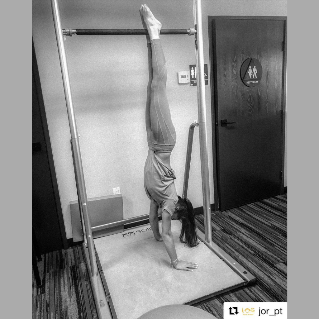 physiotherapy personal training functional exercise training equipment with girl doing handstand