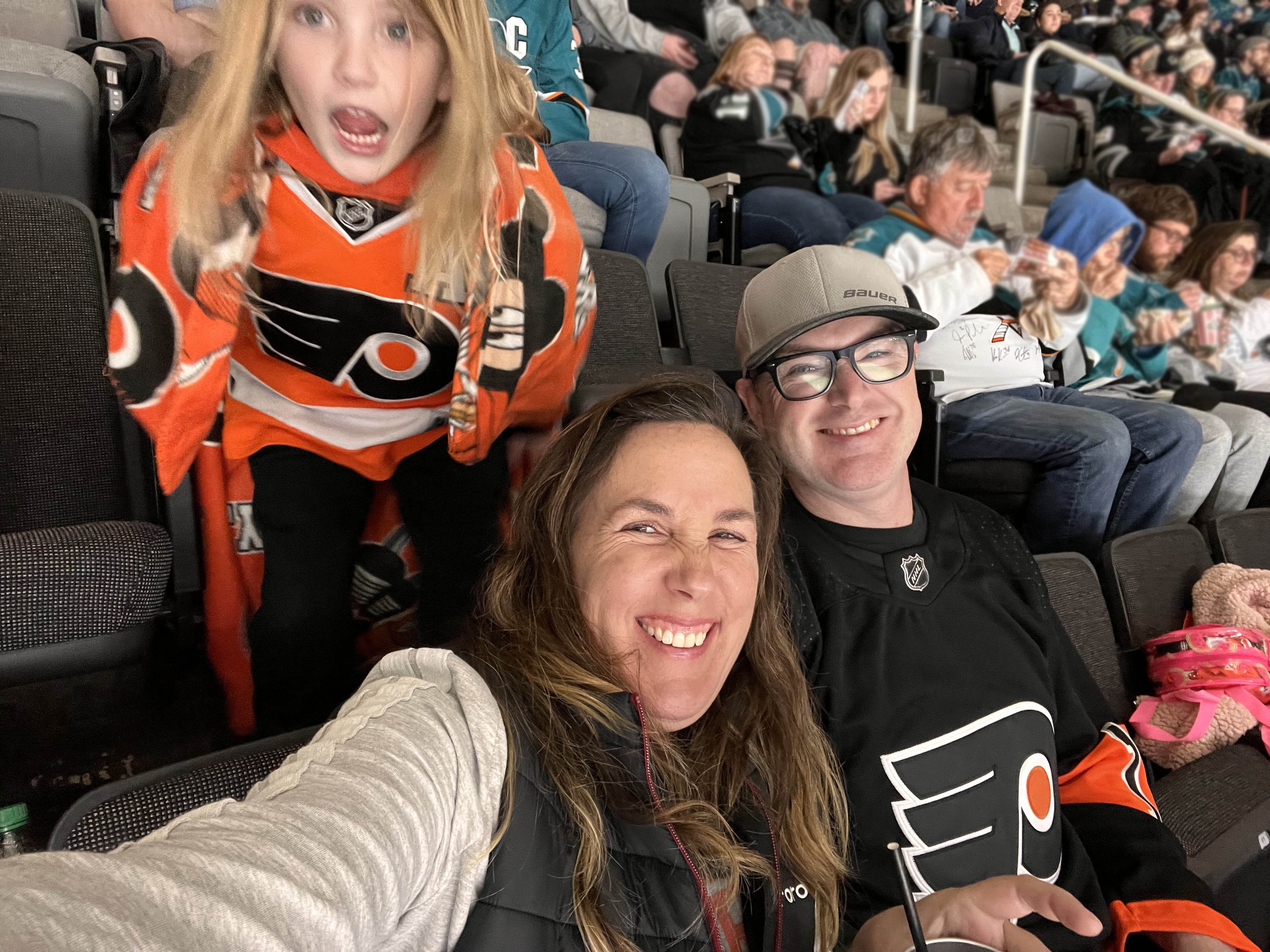 Our hockey family at a sharks game while wearing flyers gear