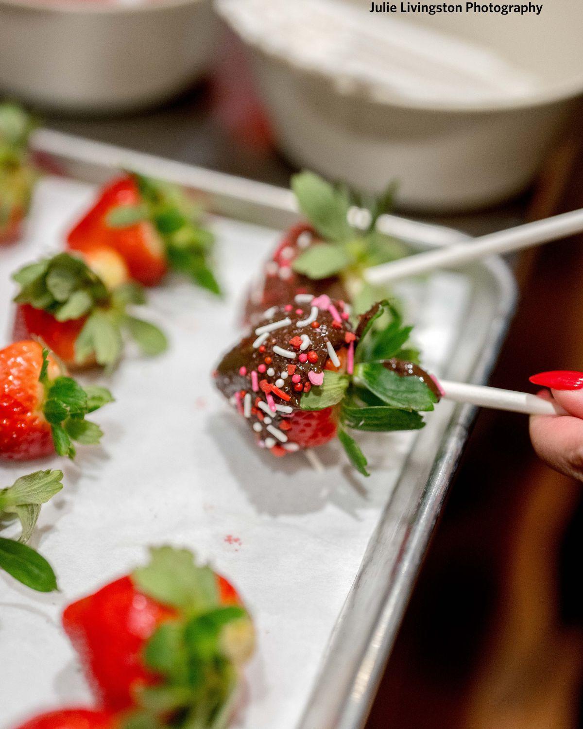 Hand-dipping chocolate-covered strawberries at River Street Sweets King Street Charleston