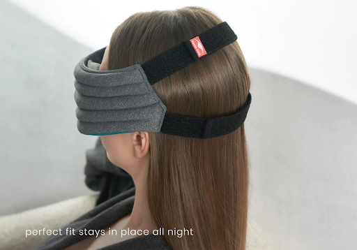 The straps of a weighted sleep mask secured around the back of a girl’s head.