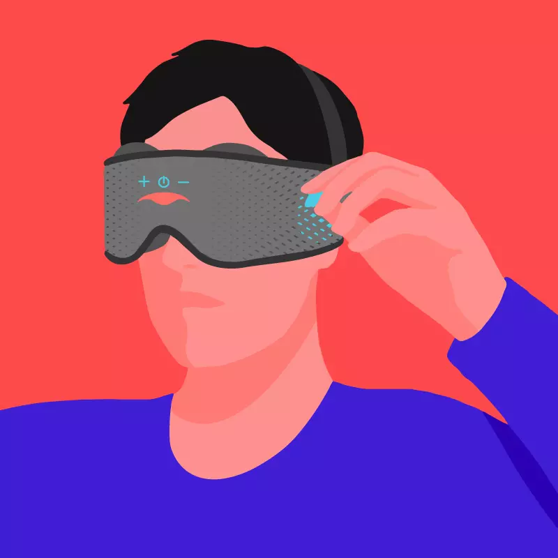 A person pulling on the blue tab of a Bluetooth speaker in a sleep mask with headphones.