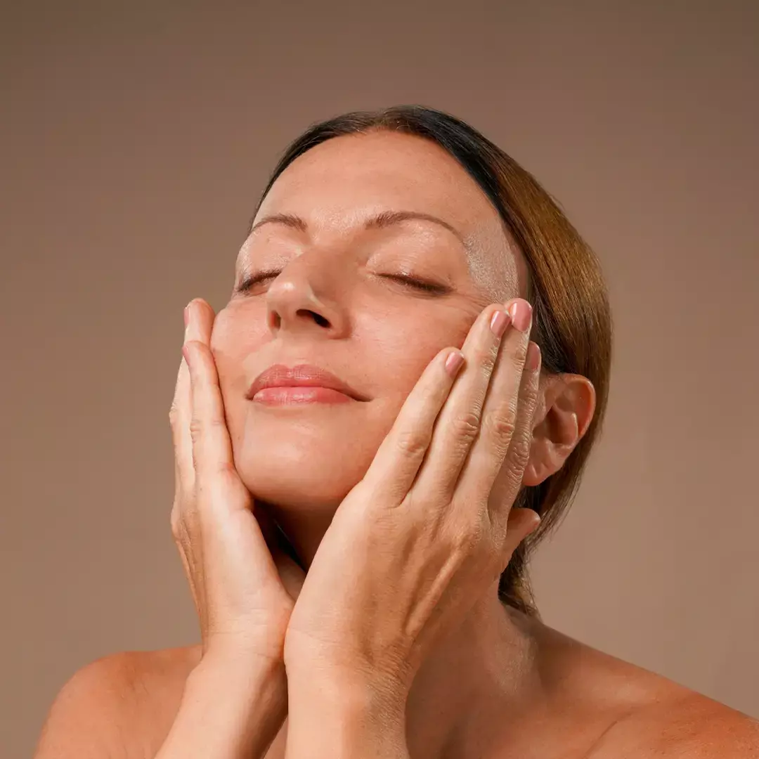 A woman massaging the serum on her face