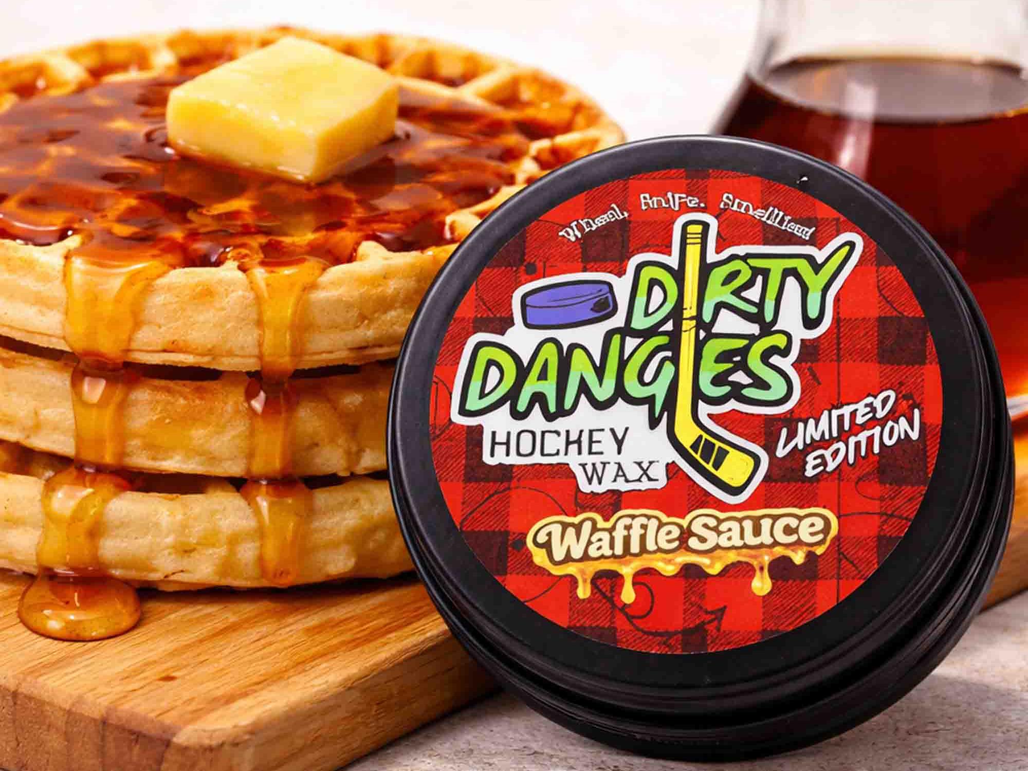Container of 'Dirty Dangles' hockey wax Waffle Sauce Scent with a stack of waffles and syrup on a wooden board.