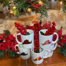 A stack of mugs under a Christmas tree