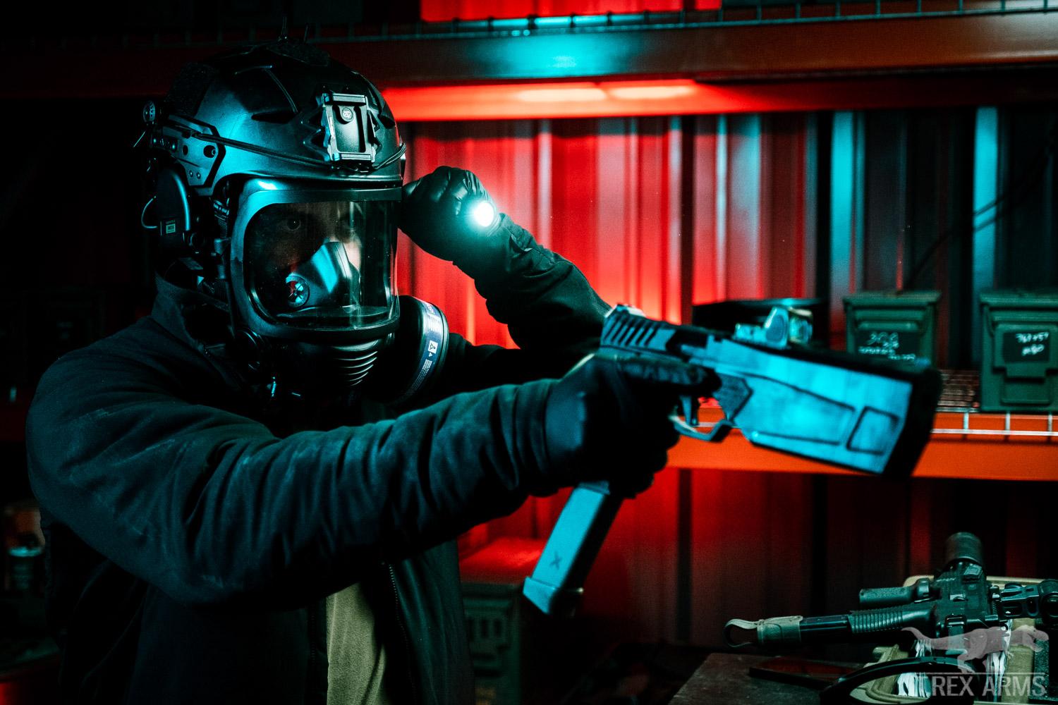 Man holding a gun and flashlight wearing a Mira Safety gas mask