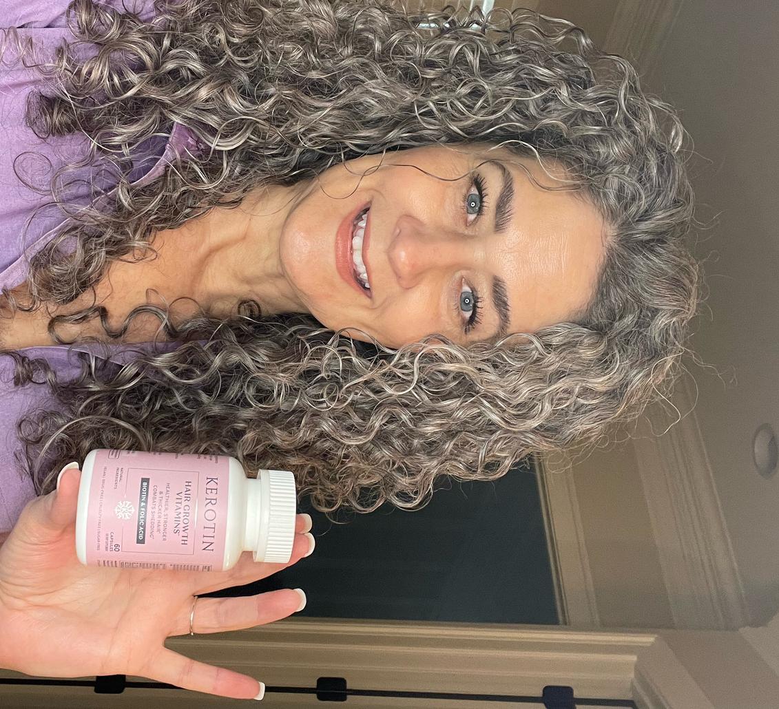 Model With Dark Hair Holding a bottle of Kerotin Hair Vitamins