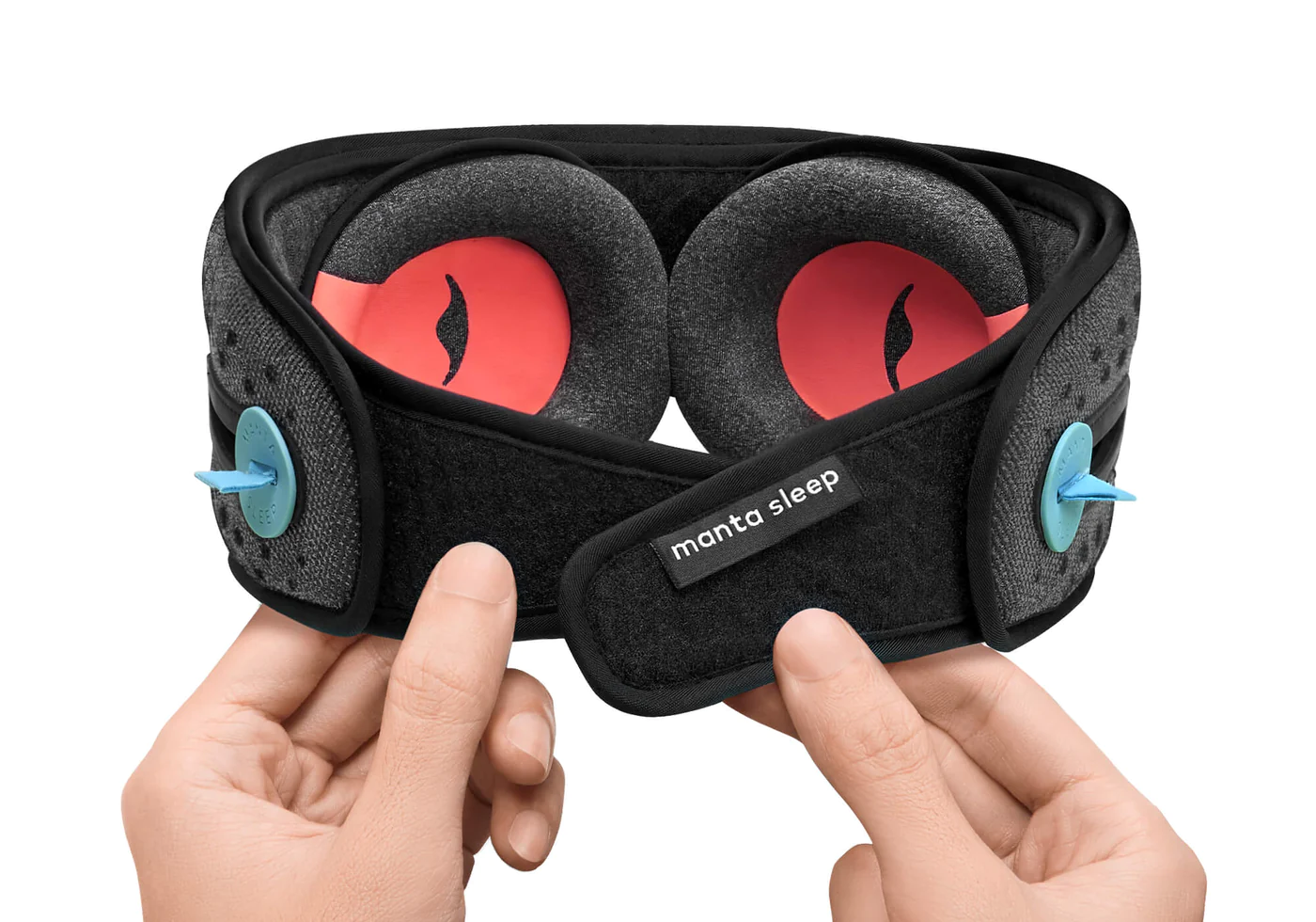Hands holding the micro hook and loop closure of a black Bluetooth sleep mask with headphones and eye cups for napping.