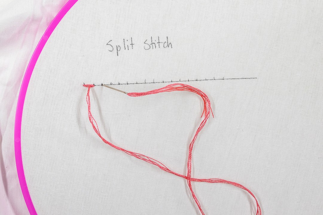 A needle splits the first stitch, creating a second one.