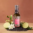 A bottle of Yauvari amplified youth spring surrounded by ingredients like black gram, cut in half limes, neroli flowers with it's buds and leaves.