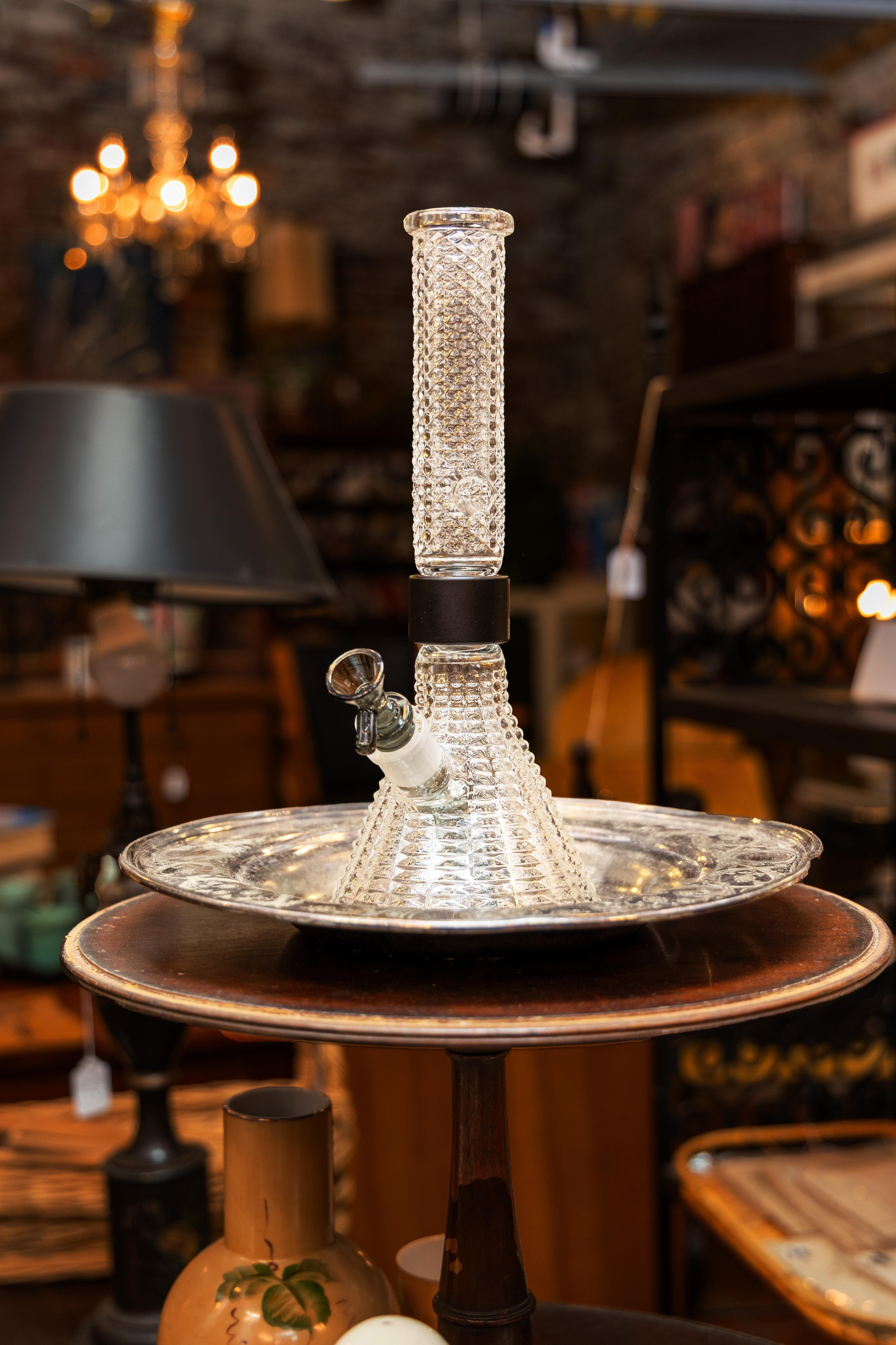 The Jane West x Prism 'Twenties' Mini Beaker sitting in an ice bucket to demonstrate thermal shock risks in smoking glass. This visual explains why high-quality borosilicate glass is essential for temperature resistance, while cautioning against extreme temperature shifts. Part of a guide on how to safely cool your modular bong without cracking the glass.