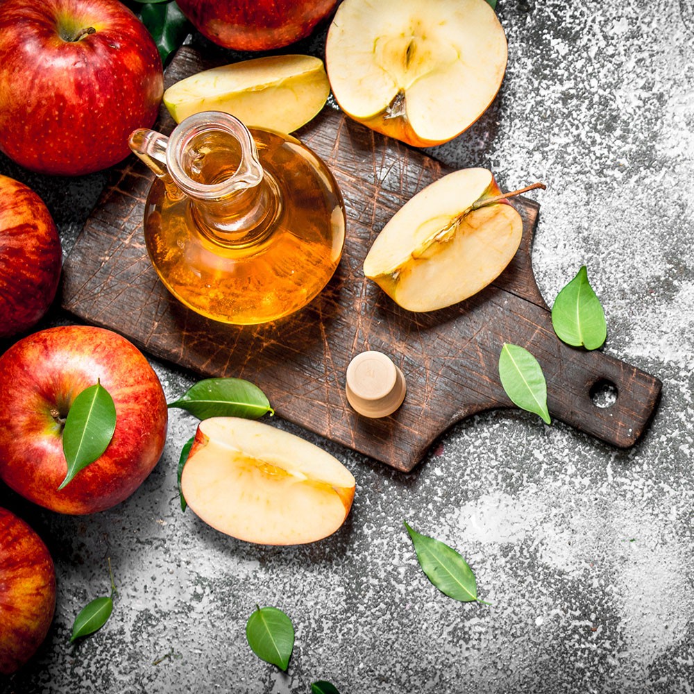 Great background with wood cutting board, apples, leaves and apple cider vinegar
