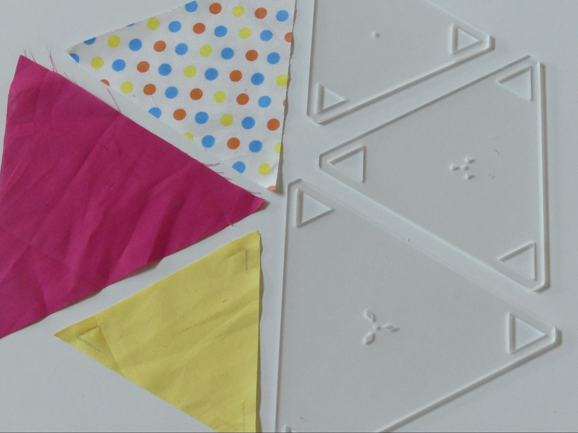 Showing a set of large triangles that had been made by fussy cutting around the large 60 degree triangle quilt templates.