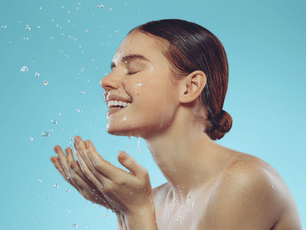 woman washing her face, preparing to use microneedling pen