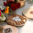 picnic table set with roses on table and a plate of small cookies