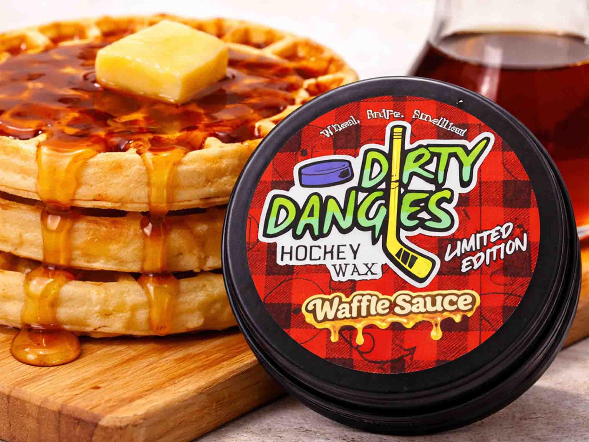 Container of 'Dirty Dangles' hockey wax Waffle Sauce Scent with a stack of waffles and syrup on a wooden board.