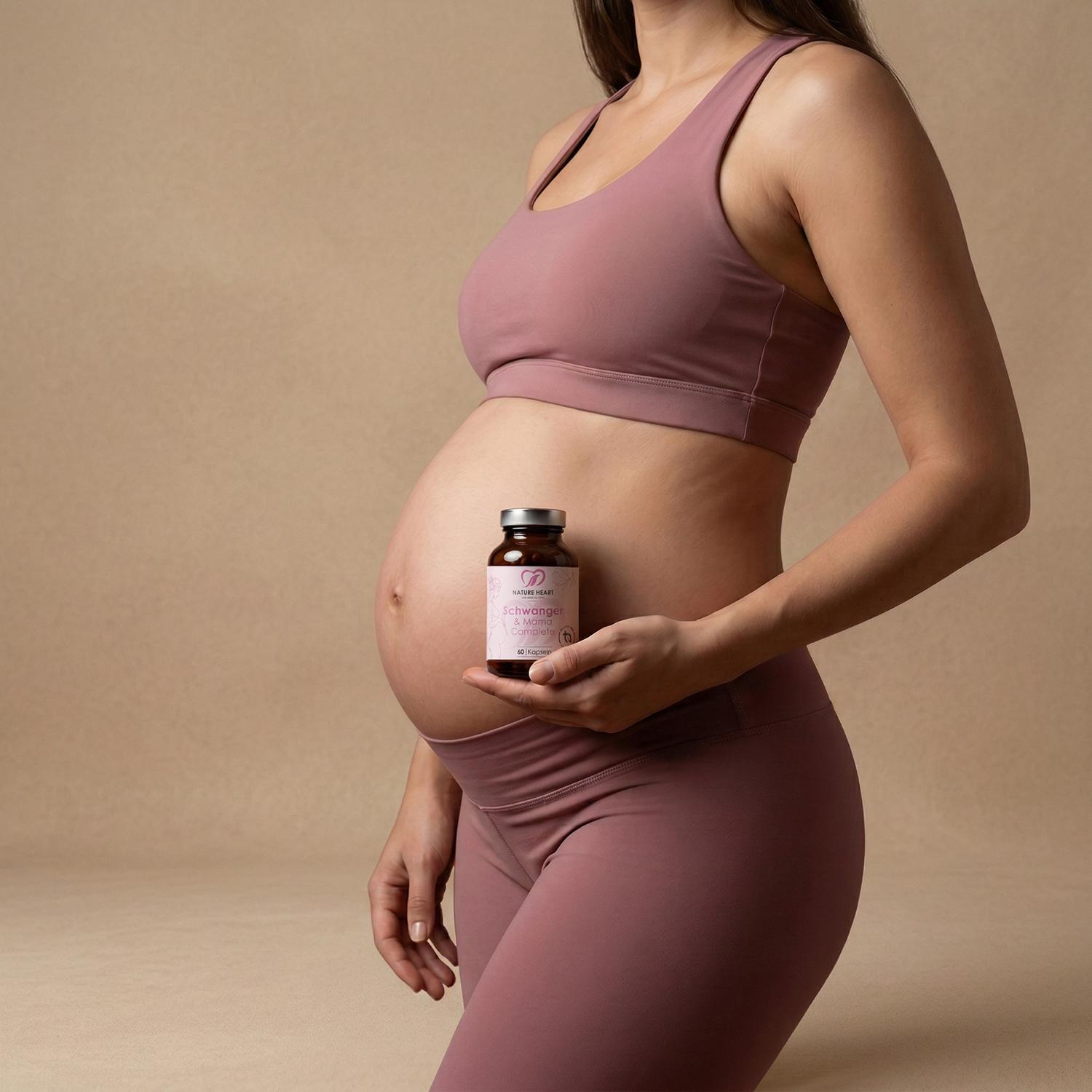Schwangere Frau im beigen Leinen-Kleid hält Nature Heart Schwanger & Mama Complete in einem hellen Wohnraum