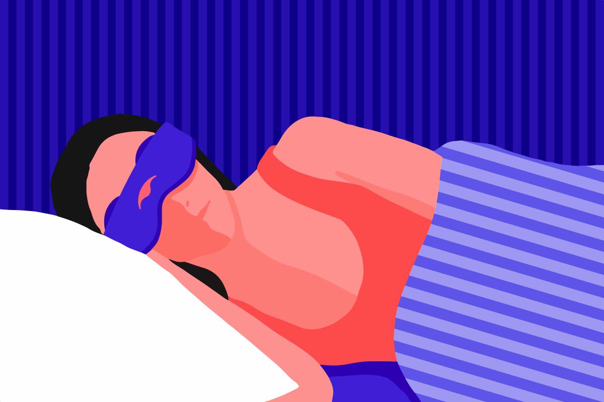 A girl wearing a silk eye mask while sleeping on her side.