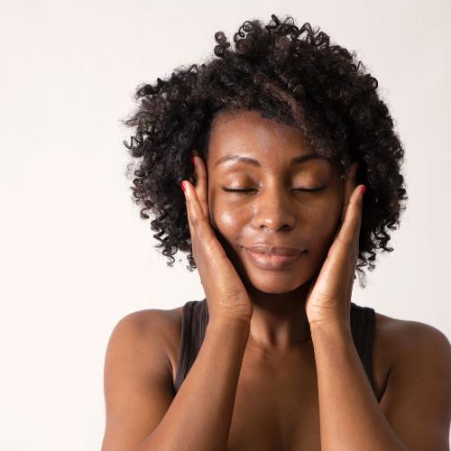 mature woman rubbing the sides of her head with her eyes closed