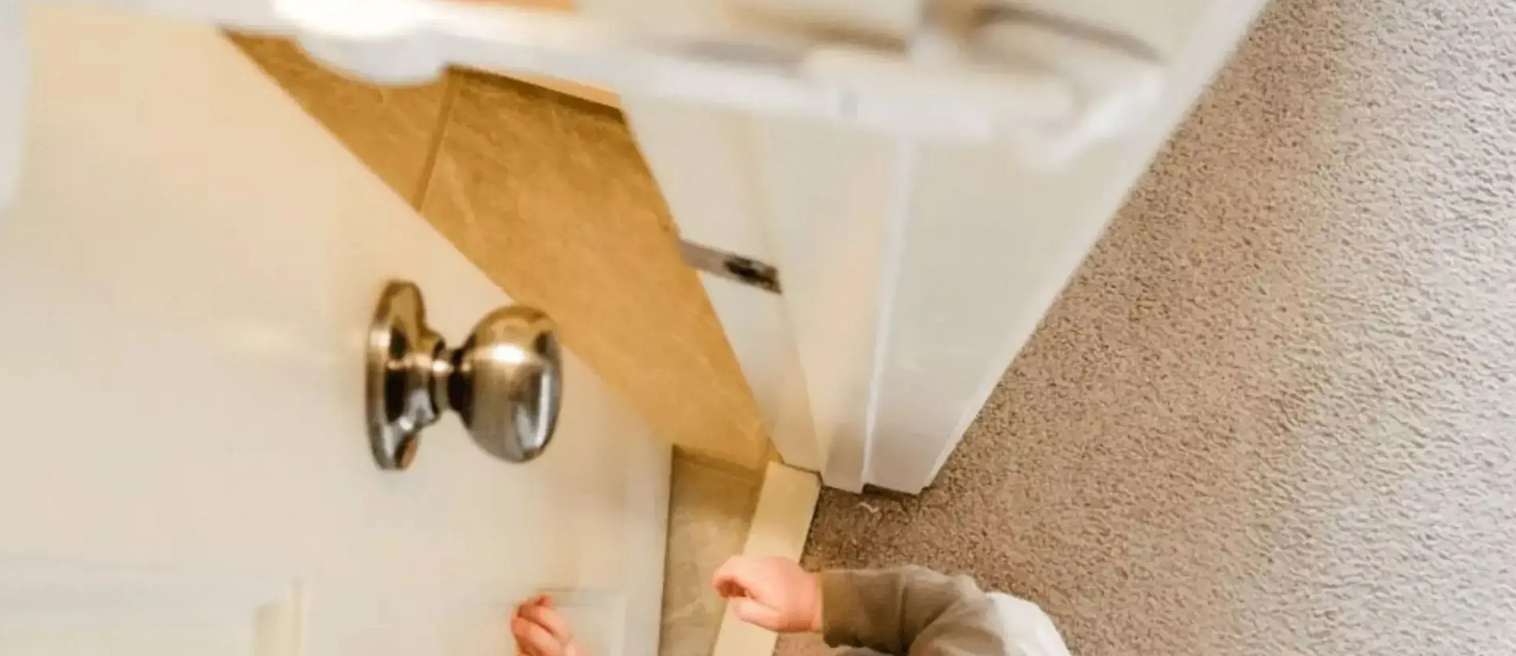 a baby trying to enter a room stopped by a door buddy door strap