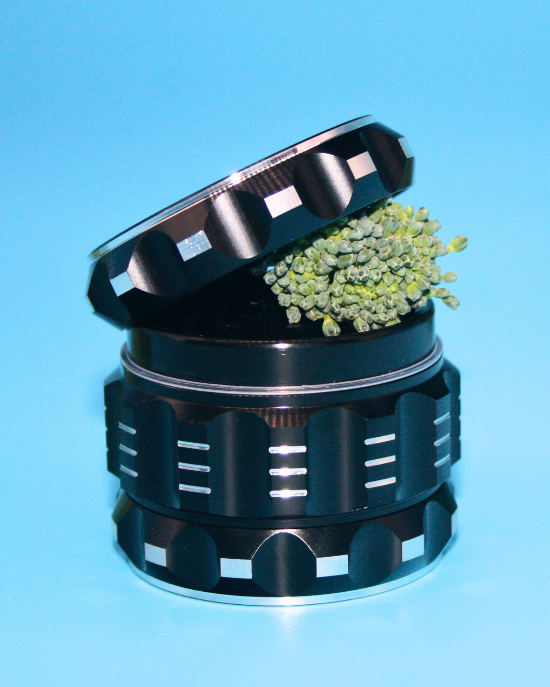 Black Prism Herb Grinder lid with material illustrating the ideal medium-coarse grind consistency for optimal airflow and a smooth smoking experience.