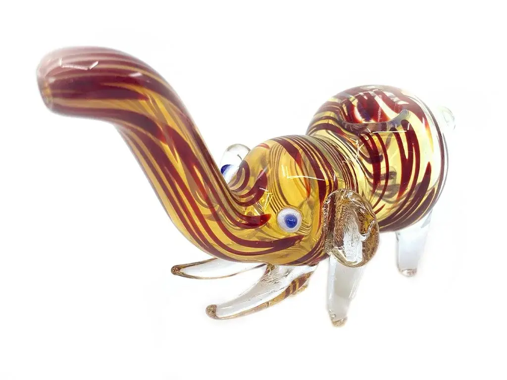 A decorative Nepali elephant pipe made from traditional soft amber glass, illustrating the style of ubiquitous smokeshop imports that the high-quality borosilicate Prism Amber Collection is designed to improve upon.