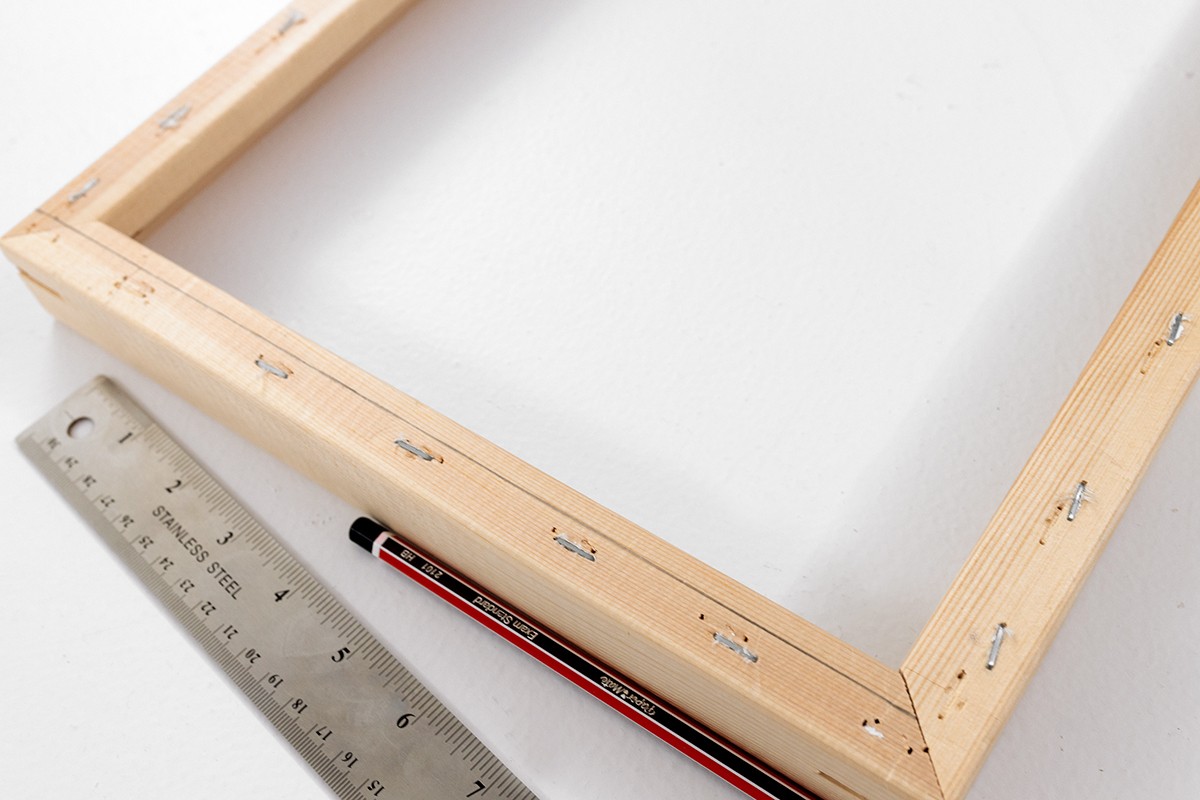 This is an image of a pencil and ruler beside an empty picture frame.
