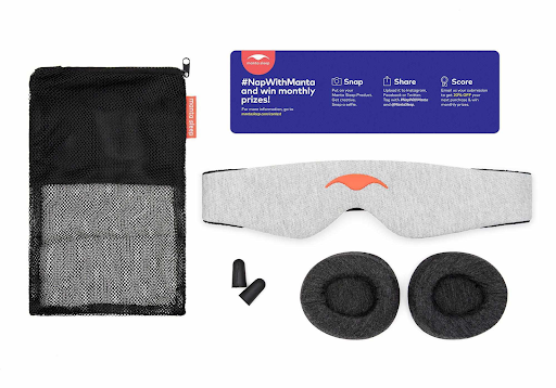 A black mesh bag, a light gray head strap, dark gray eye cups, ear plugs and care instructions for a Manta Sleep mask.