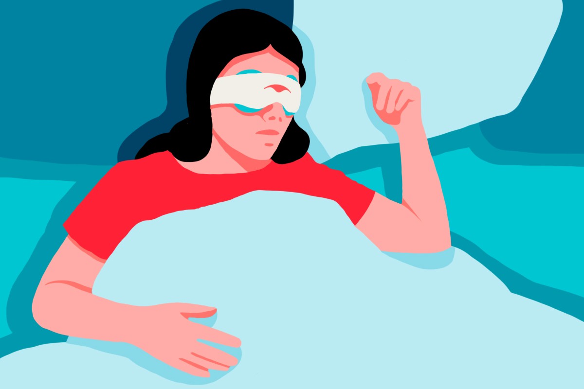 A woman lying down in bed wearing a cooling eye mask for women.