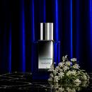 Hemlock bottle with white hemlock flowers against a blue velvet curtain