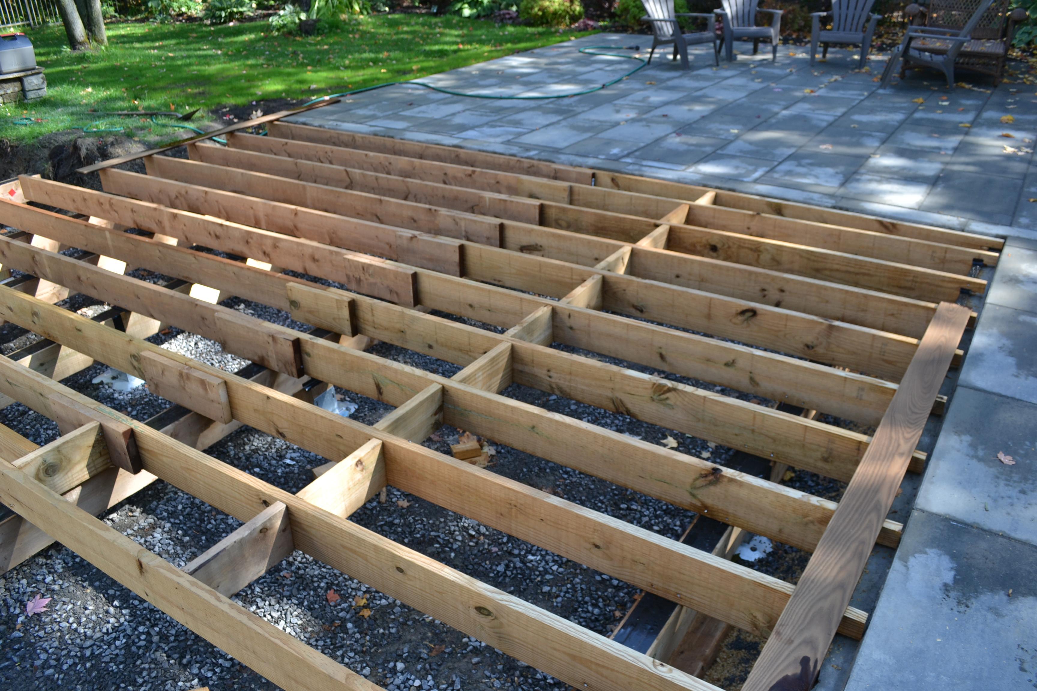 deck frame butted up against paver stone patio