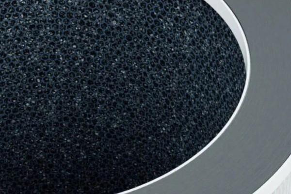 Close-up of a metallic and textured black surface with a circular design.