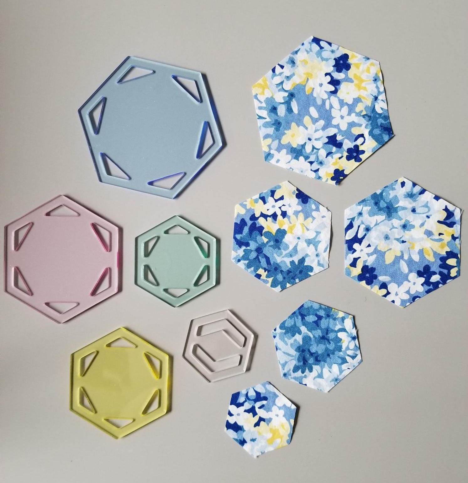 Set of small fabric hexagons that were made by cutting around a hexagon quilt template..