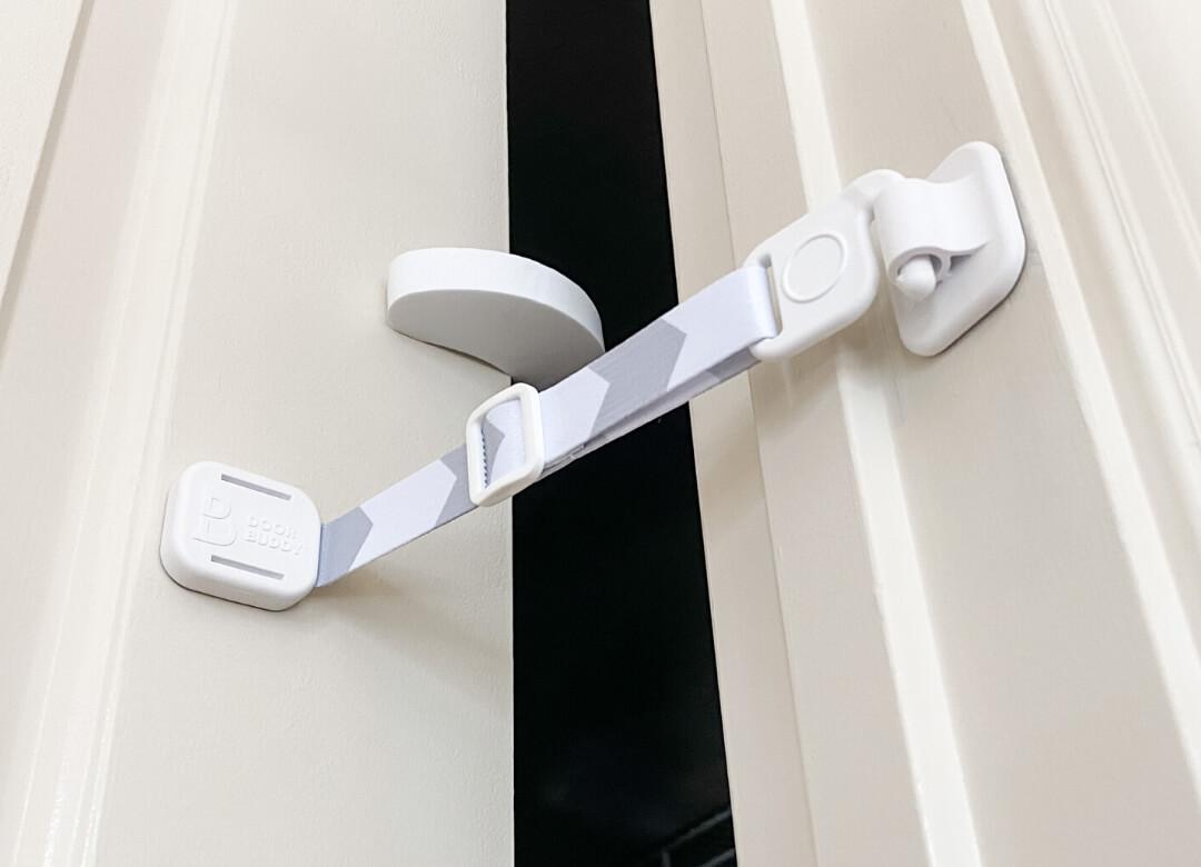 Door Buddy door strap used together with a door stopper to keep the door from closing while maintaining a safe gap for cats.