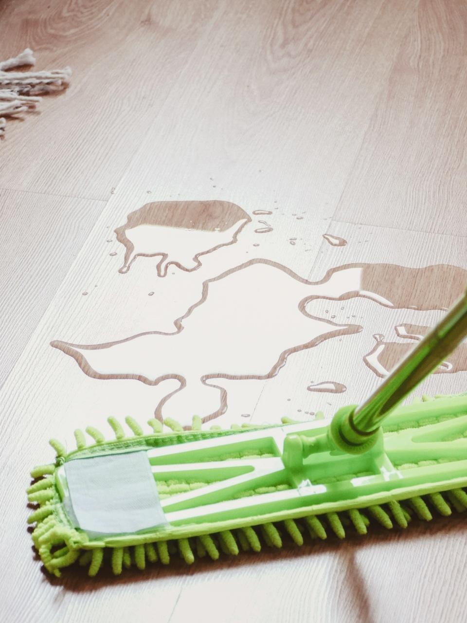 Pee on the laminated wooden floor in bedroom, mop wiping wet floor