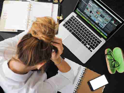 stressed girl looking at a laptop and planner