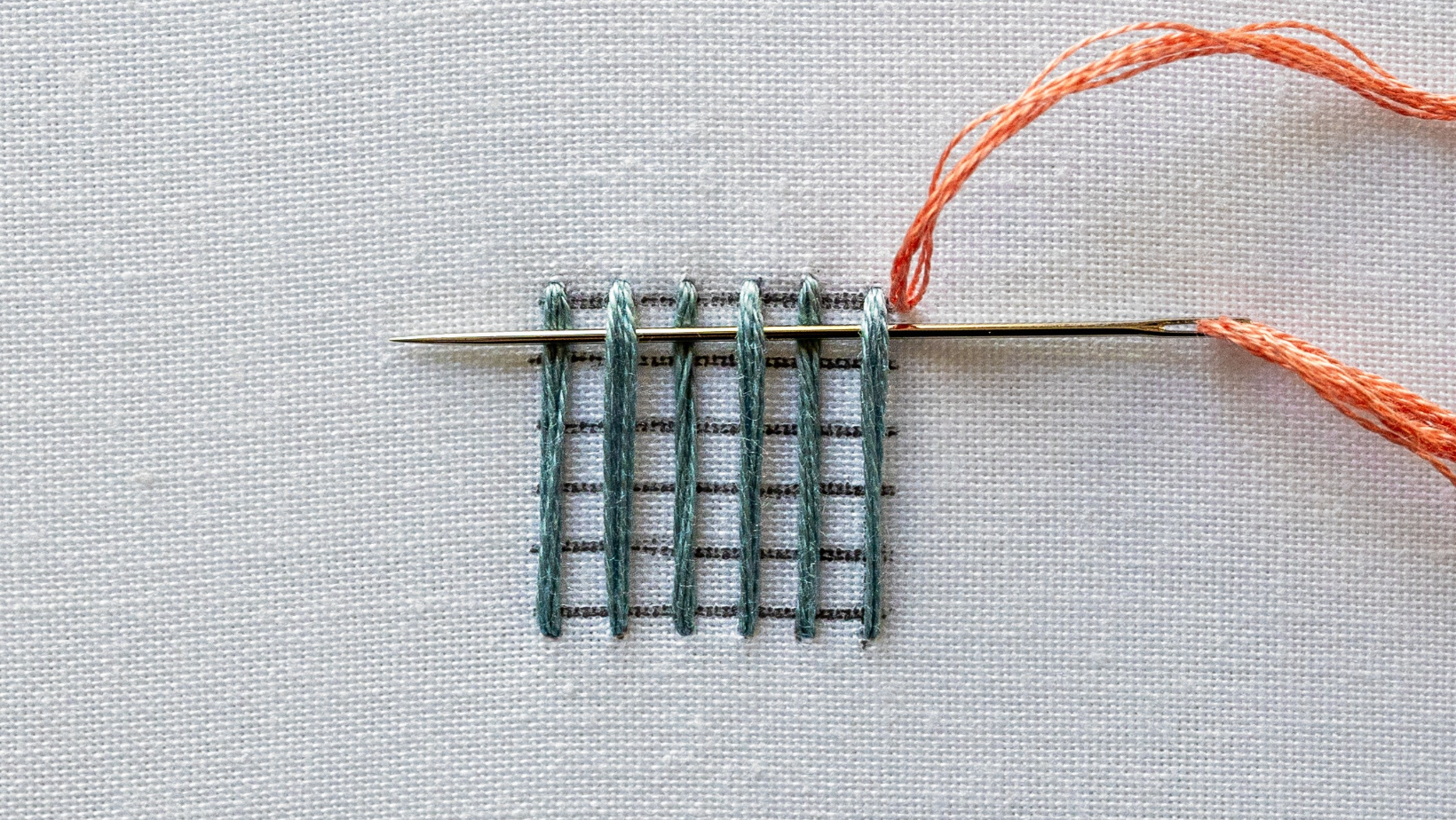 The needle continuing across the warp threads, alternating over and under