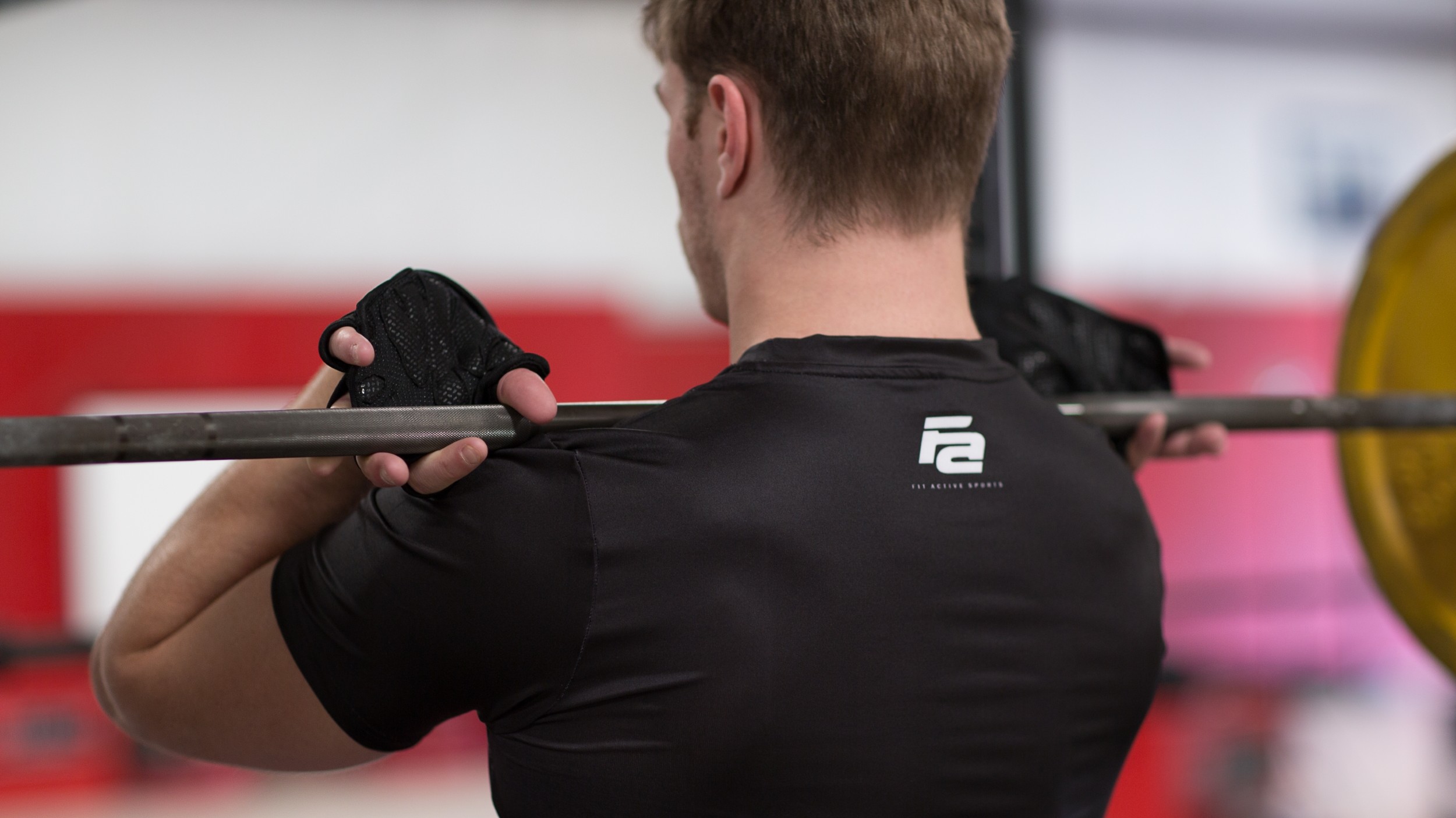 Man wearing black lever belt preparing to squat with barbell