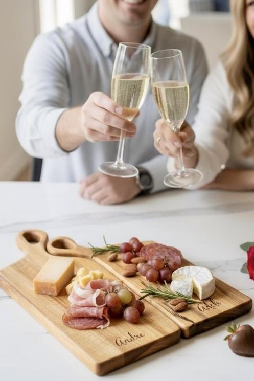 personalized charcuterie boards with engraved names used by couple celebrating with wine