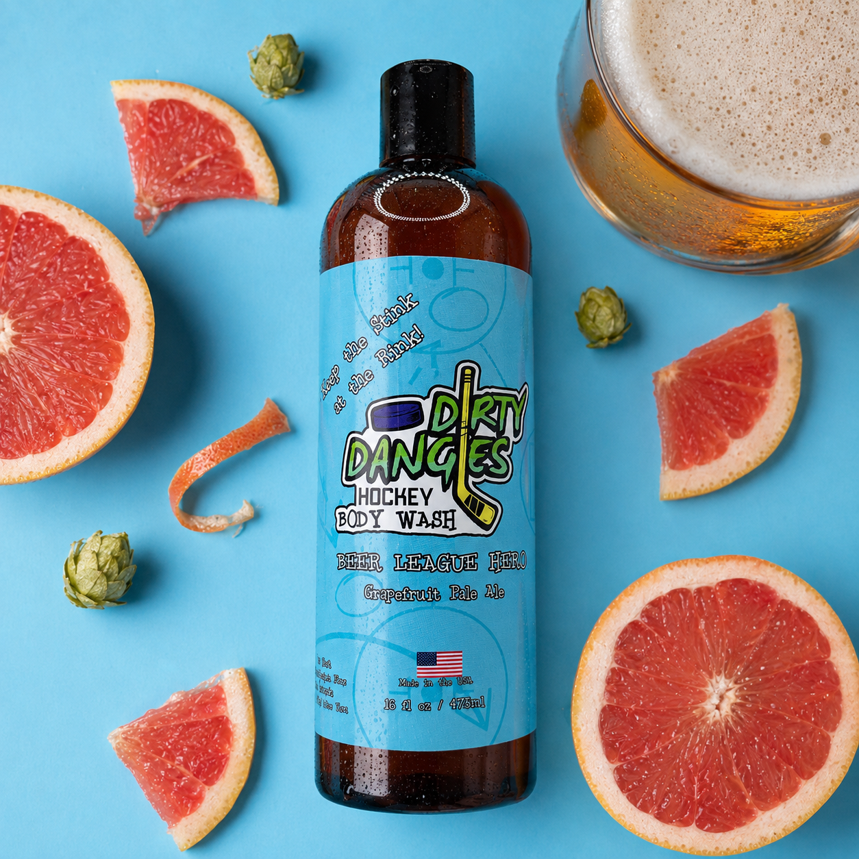 a bottle of beer league hero grapefruit pale ale hockey body wash on a blue background with grapefruit, hops and a pale ale.