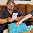 a man smiling while opening a blue dutch oven kits gift box