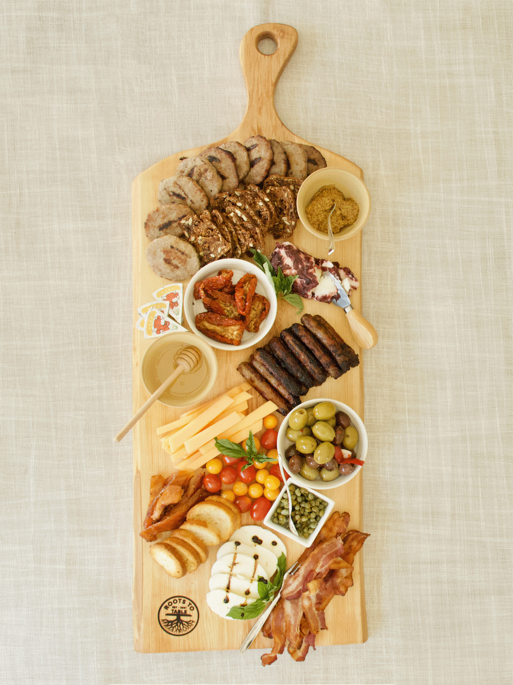 Live edge maple charcuterie board being served full of snacks.