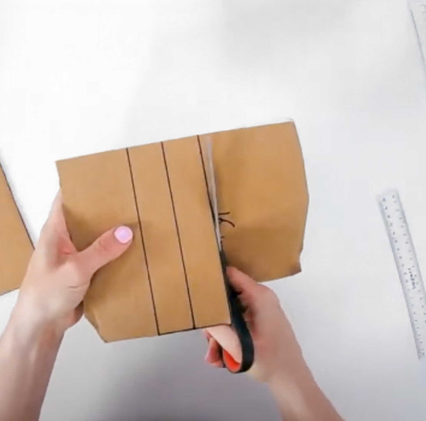 A hand cuts out struts of cardboard.
