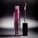 Plumping Lip Gloss - Berry Pout vial standing next to applicator with shadows in background