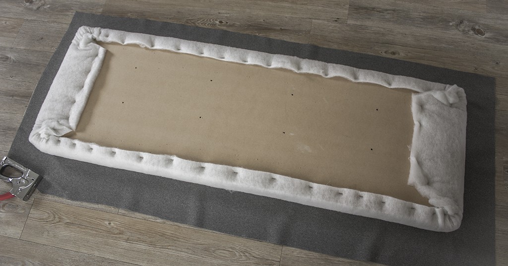 Fabric is laid underneath the foam board.