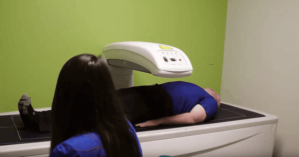 Woman with Man on Medical Machine Green Wall