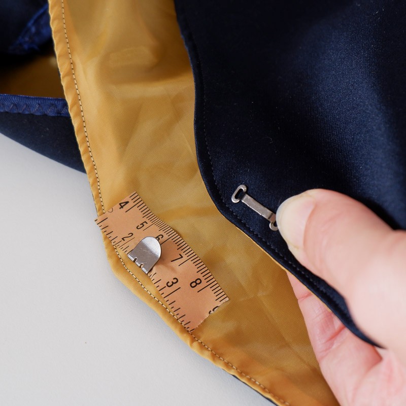 Using washi tape to hold the hook in place before sewing on a waistband that does not have a zipper and finding the bar placement