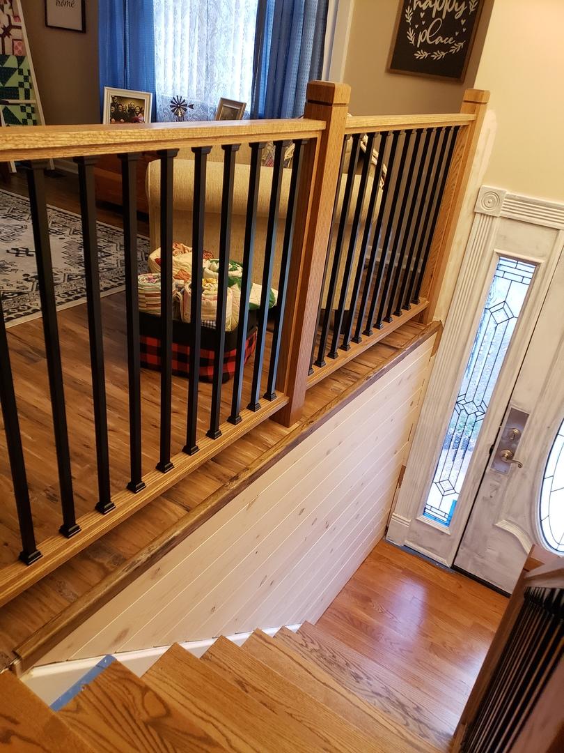 photo of an indoor wood railing with square black snap'n lock balusters installed on it