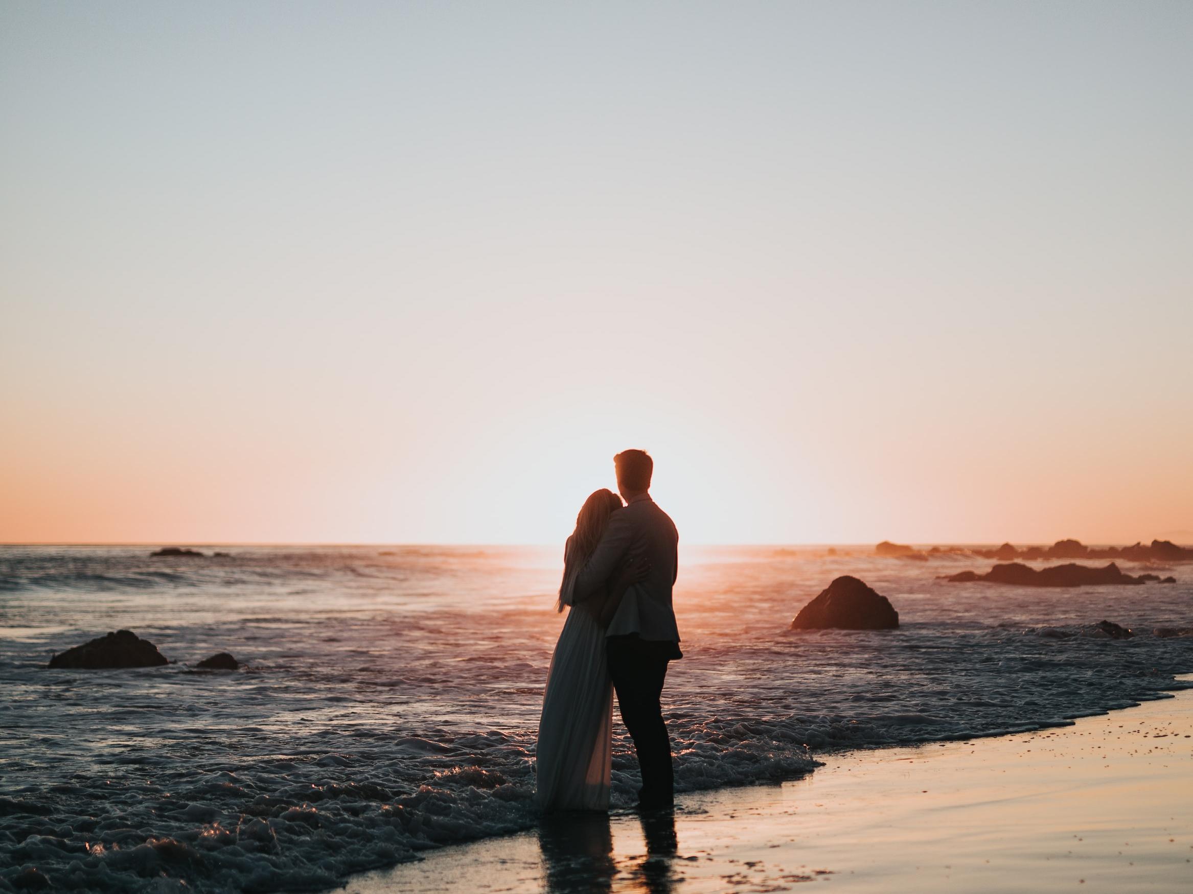 Couple at a beach, perfect location for a beach proposal.