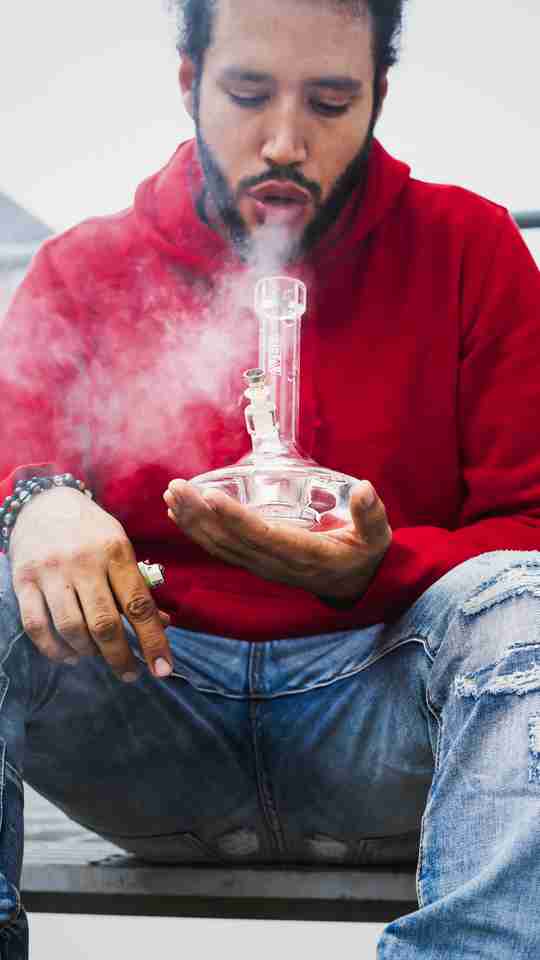 man in red smoking from a dab rig