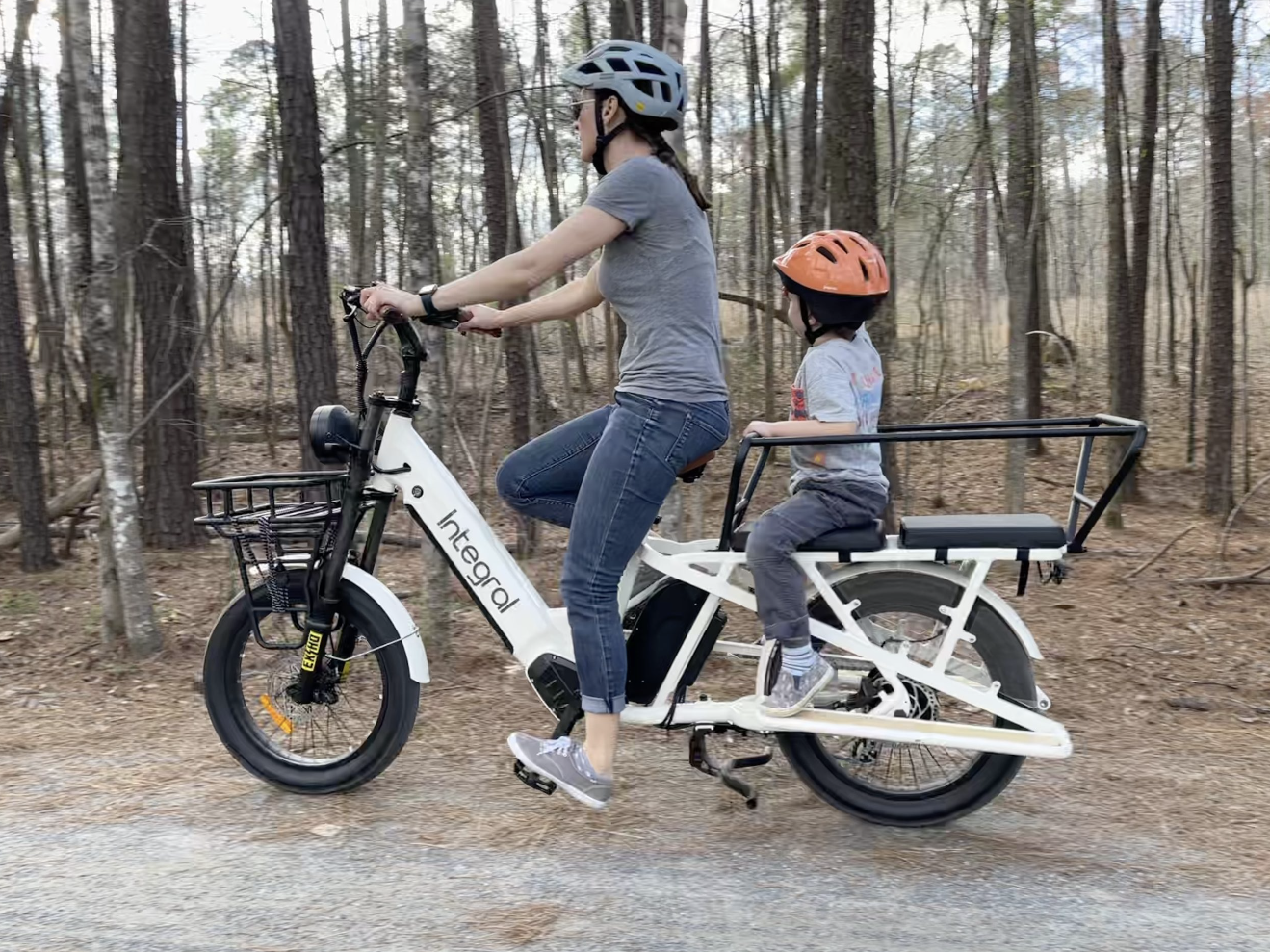 woman and five yar old child riding an electric cargo ebike on a nature trail